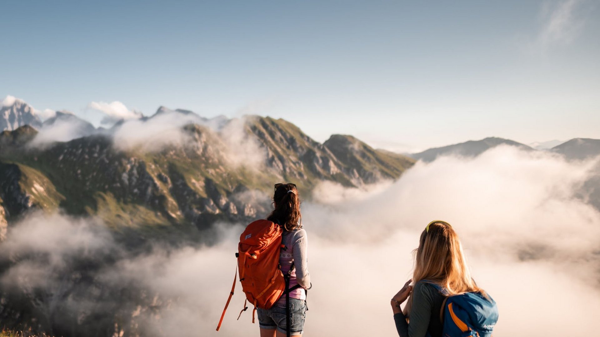 Lahnerhof: Natur- und Wellnesshotel bei Sterzing Zwei Wanderer mit Rucksäcken genießen Bergblick über Wolken