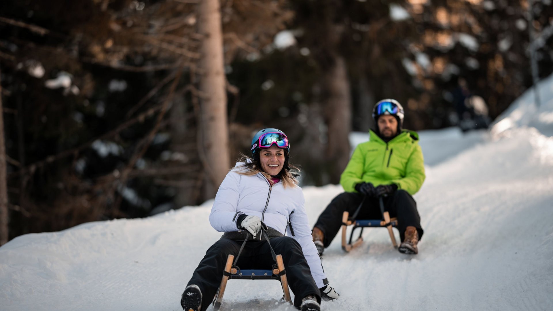 Il Lahnerhof: un hotel al Monte Cavallo, Vipiteno Due persone slittano giù per una collina innevata indossando caschi e abbigliamento invernale