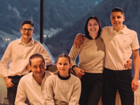Lahnerhof: Natur- und Wellnesshotel bei Sterzing Sechs lächelnde Familienmitglieder vor Fenster mit Bergblick