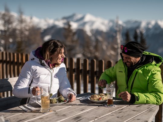 Il Lahnerhof: un hotel al Monte Cavallo, Vipiteno Coppia che mangia all'aperto con montagne sullo sfondo