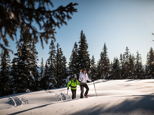 Il Lahnerhof: un hotel al Monte Cavallo, Vipiteno Due persone che fanno escursione con le ciaspole in paesaggio innevato sotto cielo sereno
