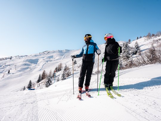 Il Lahnerhof: un hotel al Monte Cavallo, Vipiteno Due sciatori con casco e occhiali sulla neve con cielo azzurro