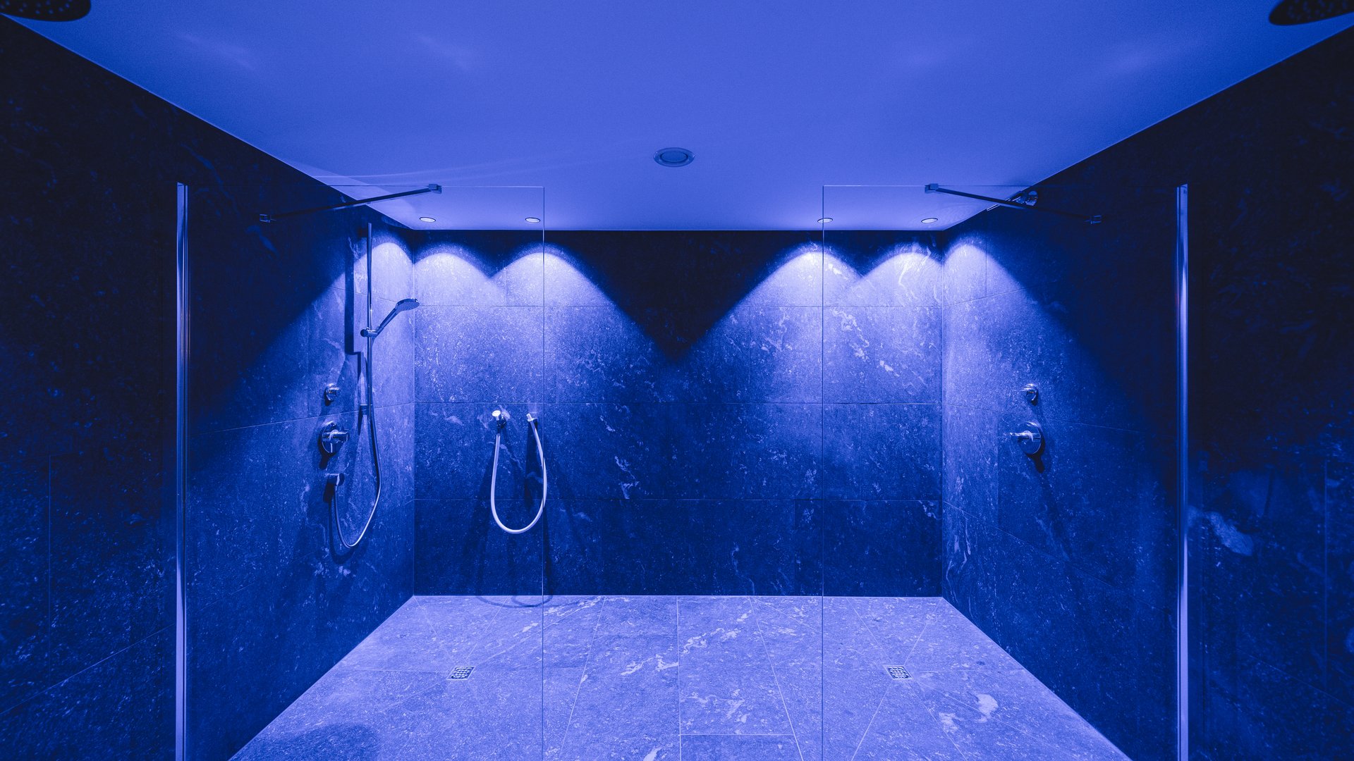 Cercate un hotel a Vipiteno con spa? Benvenuti al Lahnerhof! Area doccia moderna con illuminazione blu e due docce