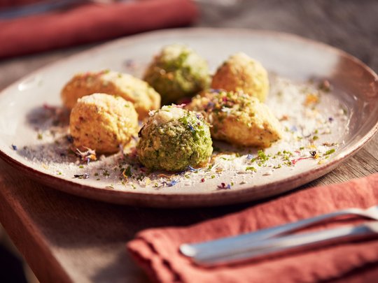 Benvenuti nel ristorante del nostro hotel con spa a Vipiteno Canederli colorati su un piatto decorato con erbe e spezie
