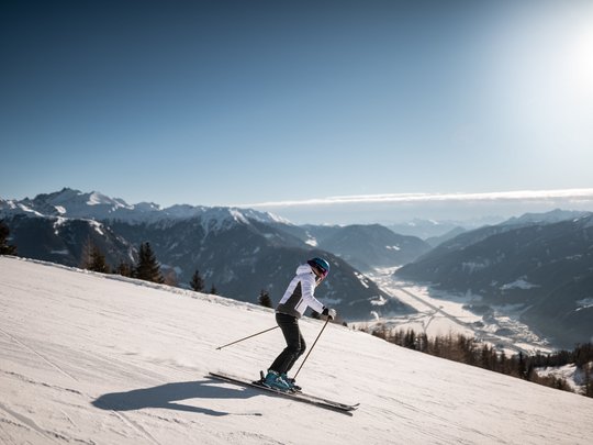 Il Lahnerhof: un hotel al Monte Cavallo, Vipiteno Scalatore scia su una pista innevata con montagne e sole sullo sfondo