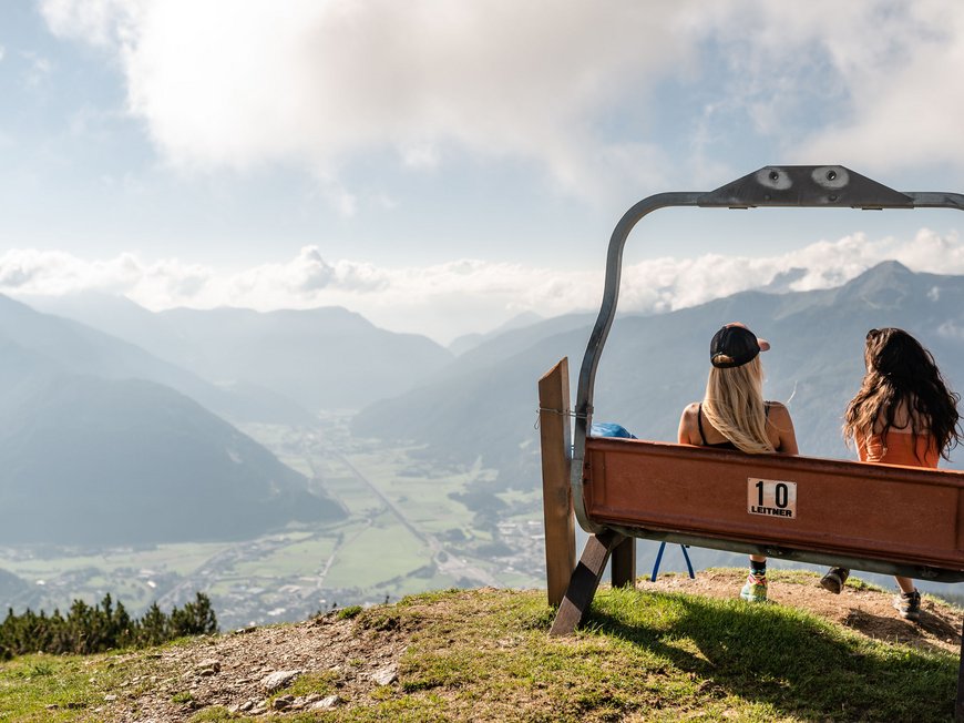 Il Lahnerhof: il vostro hotel vicino a Vipiteno centro Due donne siedono su una panchina guardando le montagne e la valle
