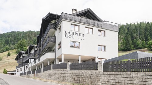 Zimmer und Suiten in unserem Hotel am Rosskopf Hotel Lahnerhof an einer Landstraße mit Wald im Hintergrund